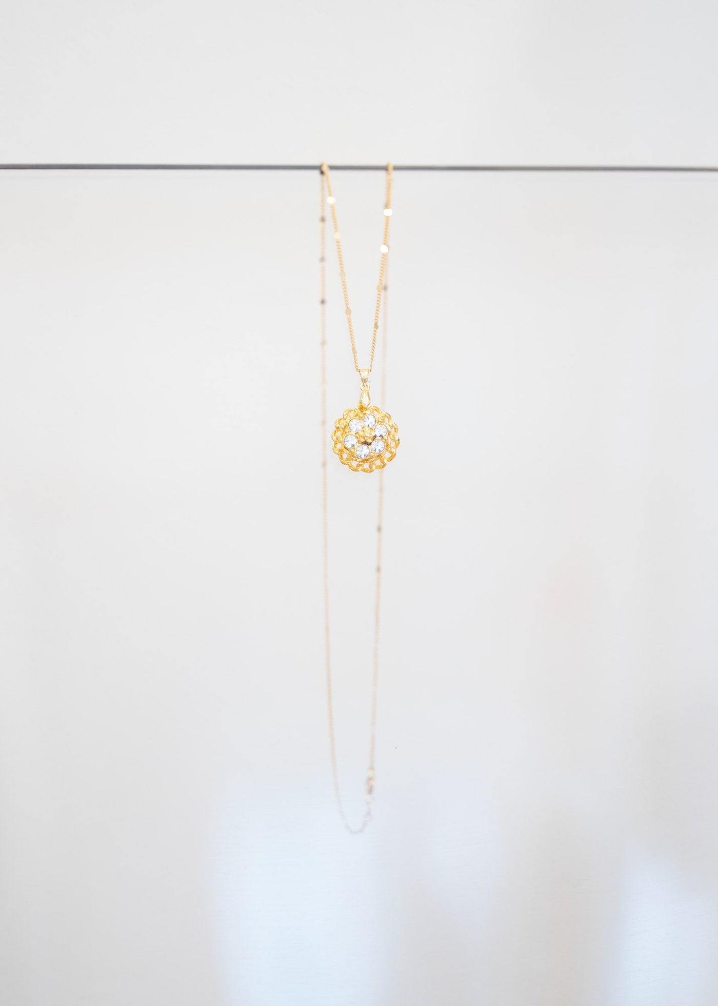 Collier « Rosace » — pendentif fleur dorée ajourée sertie de cristaux incolores, sur fine chaîne plaquée or à pastilles. Joyeux Joyaux par Alexandra Lambert.