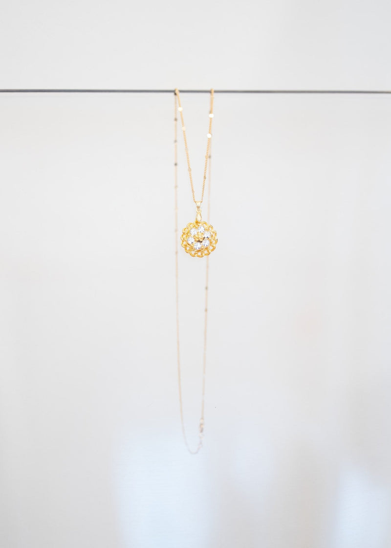 Collier « Rosace » — pendentif fleur dorée ajourée sertie de cristaux incolores, sur fine chaîne plaquée or à pastilles. Joyeux Joyaux par Alexandra Lambert.